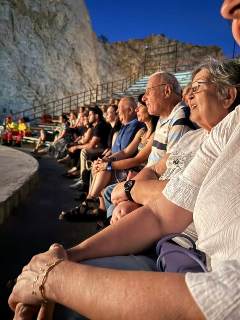 Ωφελούμενοι του ΚΗΦΗ Δάφνης-Υμηττού παρακολουθούν θεατρική παράσταση στο Θέατρο Βράχων στο πλαίσιο του Φεστιβάλ στη Σκιά των Βράχων 2026.
