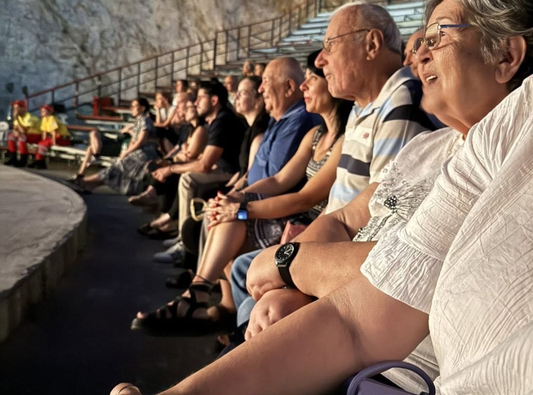 Ωφελούμενοι του ΚΗΦΗ Δάφνης-Υμηττού παρακολουθούν θεατρική παράσταση στο Θέατρο Βράχων στο πλαίσιο του Φεστιβάλ στη Σκιά των Βράχων 2026.